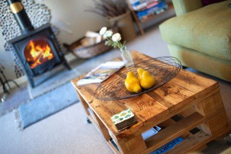 Coffee table with lit woodburner behind